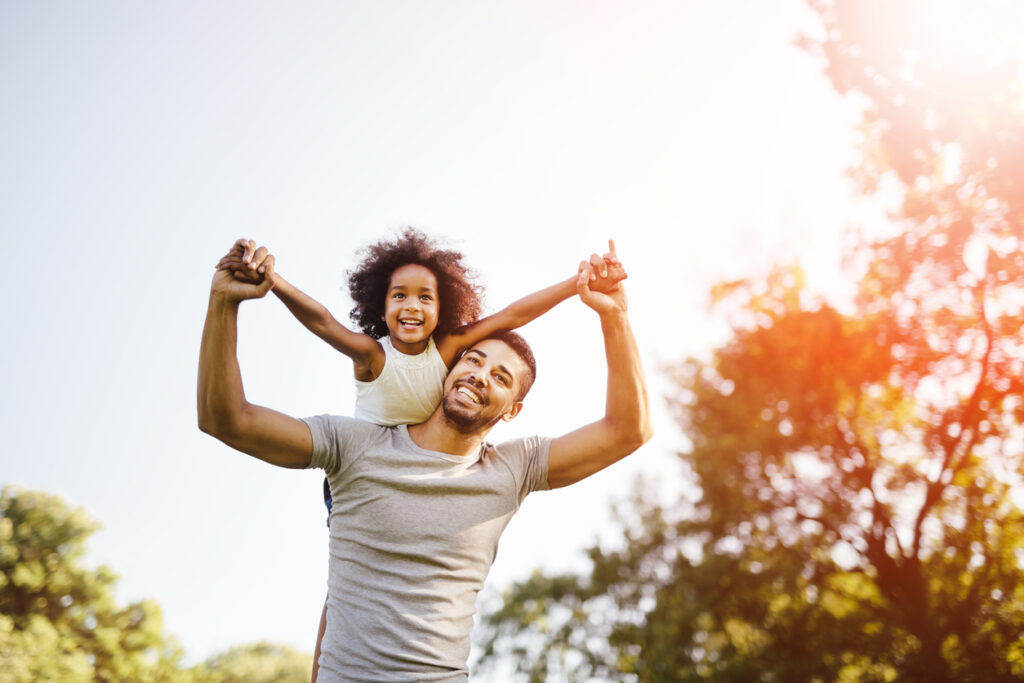 father carrying daughter piggyback
